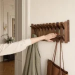 Porte-manteau mural en bois foncé format carré compact